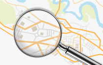 Magnifying glass zooming in on a street map graphic.